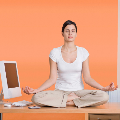Woman doing yoga on her desk at work. How to Manage Stress at Work - Whole Family Living