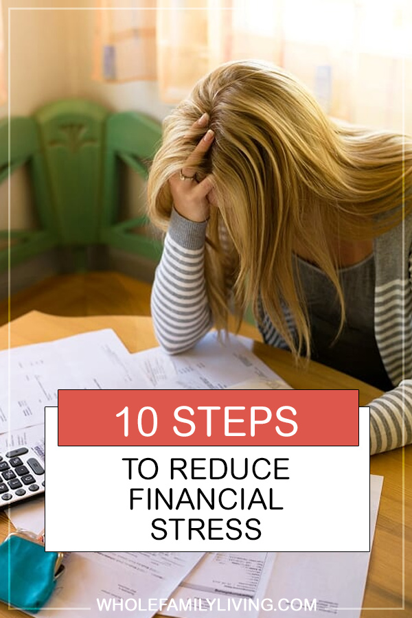 10 Steps to Reduce Financial Stress and Start Living Your Life. Woman sitting at desk looking at stack of bills.