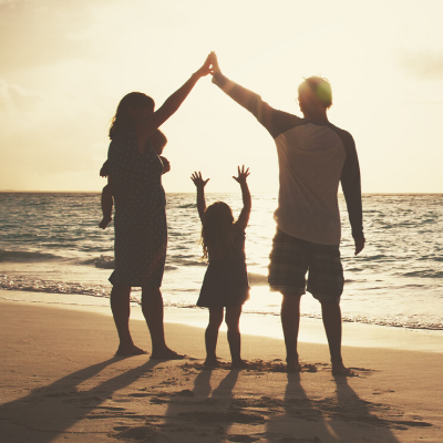 Family standing on the beach at sunset. 12 Steps to Improve Family Wellness - Whole Family Living